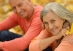 Beautiful happy old people sitting in the autumn park